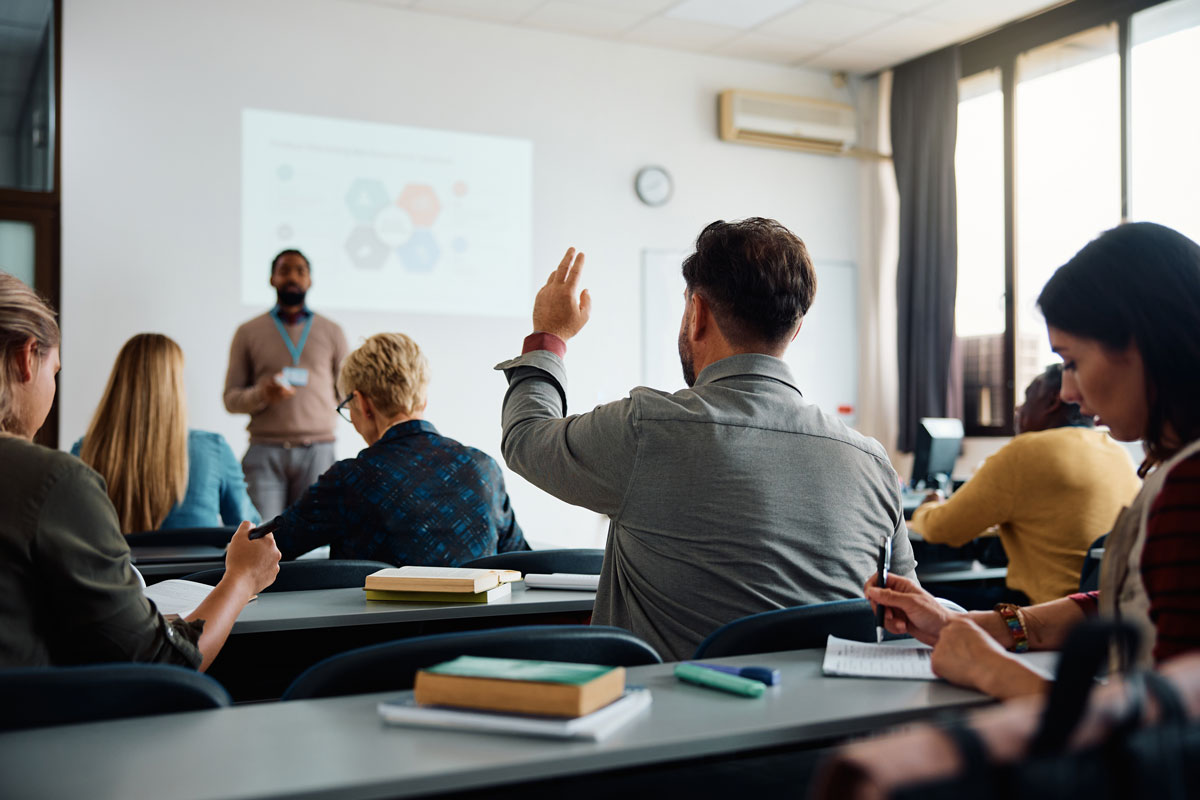 Person raising hand in classroom